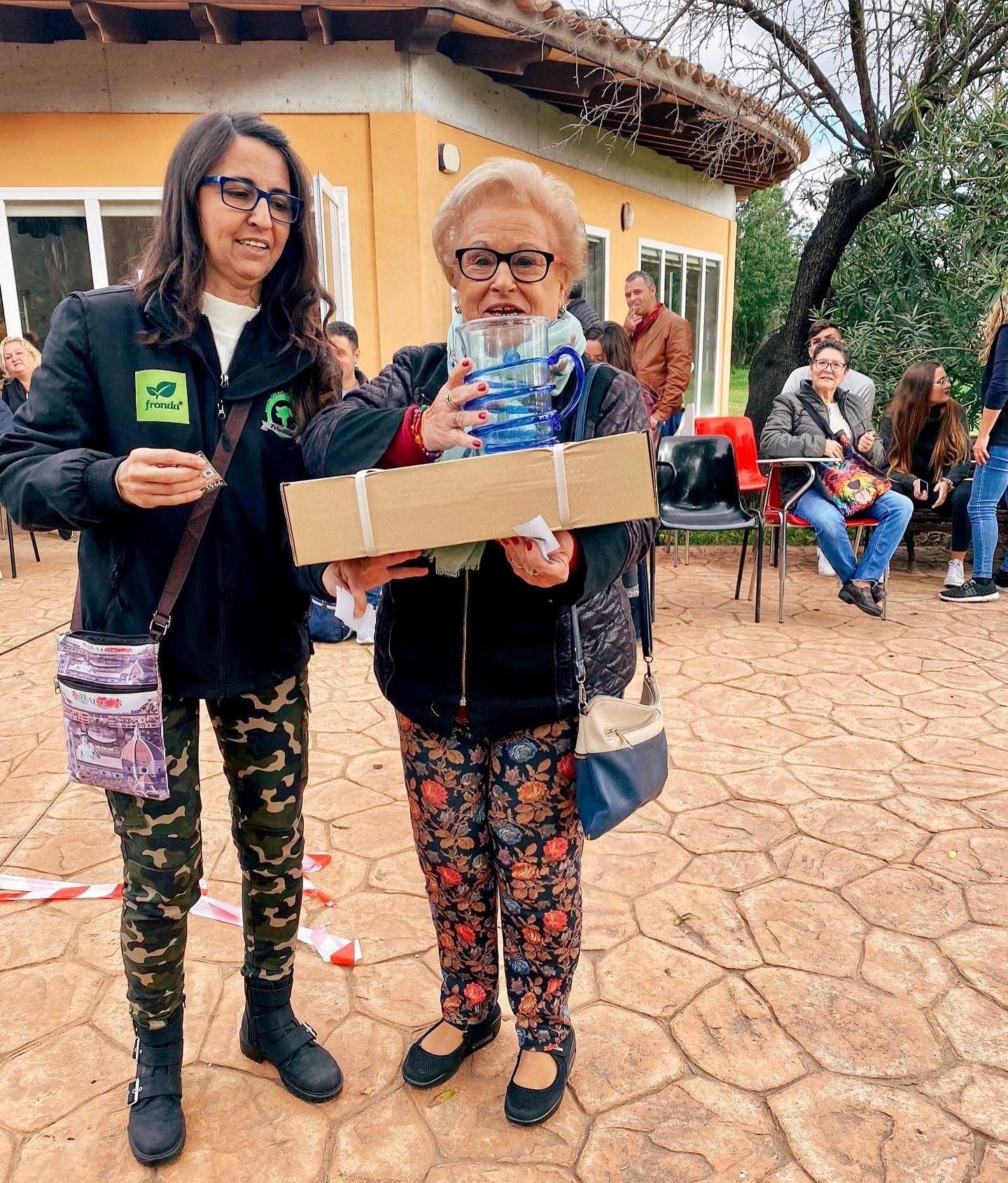 Dos voluntarias sostienen una caja en un evento